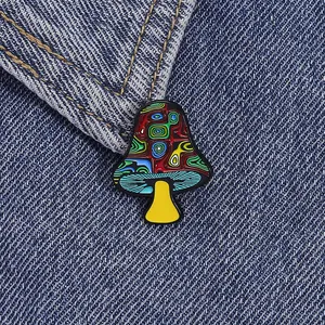 Künstlerische Emaille-Brosche im Pilz-Design mit bunten Wirbeln auf Denim-Hintergrund