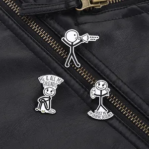 Close-up of three black and white stick figure enamel pins on a black leather jacket