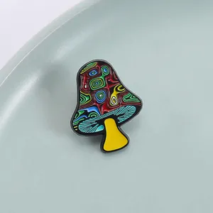 Nahaufnahme der Pilz-Emaille-Anstecknadel mit bunten psychedelischen Streifen und gelbem Stiel