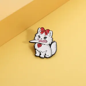 Detailed view of a white enamel cat brooch with red bow and heart pendant