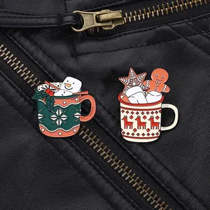 Dettaglio di spille natalizie in smalto con tazze festive e omino di pan di zenzero su pelle