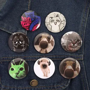 Acht süße Hunde- und Katzen-Anstecker aus Weißblech auf einer Jeansjacke dekoriert