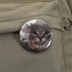 Detail eines niedlichen Blechansteckers mit Mem-Serval auf einem militärgrünen Rucksack