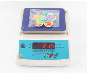 Fidget spinner tie-dye con bolle colorate su una bilancia elettronica con peso di 27,4g