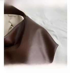 Close-up of deep coffee brown faux leather tote bag with fine lychee grain texture