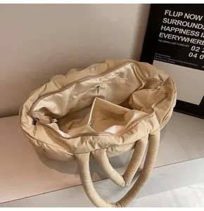 Spacious interior of beige quilted tote bag showing smooth lining and inner zipper pocket