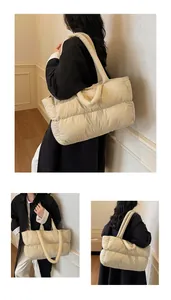 Detail of soft quilted puffer tote bag in cream white showing puffy texture and twin handles