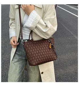 Detail of dark brown woven texture handbag with wooden bead charms on shoulder strap