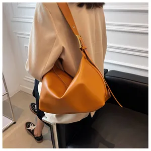 Detail of orange faux leather tote bag showing soft texture and golden strap buckle