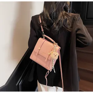 Detailed back view of pink PU leather backpack with decorative bear charm and gold buckles