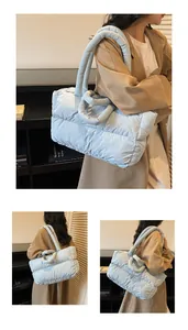 Detail showing soft light blue quilted puffer tote bag with thick tubular handles