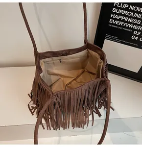 Detail view of coffee brown fringe tote with soft suede texture and magnetic closure