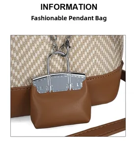 Detailed view of a brown leather bag charm with silver buckle on a woven tote bag