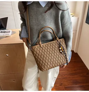 Brown woven texture handbag detail with round handle and beaded fringe tassel accent