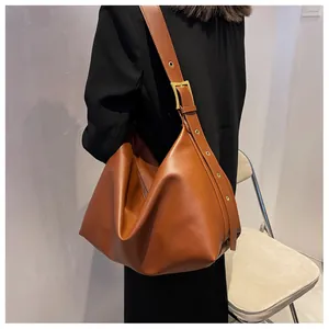 Close-up of caramel brown Hobo bag with wide adjustable strap and golden metal eyelets