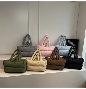 Multiple colorful quilted puffer tote bags displayed in a vertical tiered arrangement