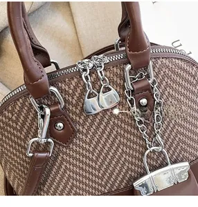 Detail view of vintage brown tweed bag showing woven texture and silver zipper pull