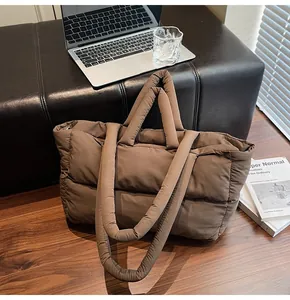 Detail view of large dark brown quilted tote bag with soft padded texture and top handles
