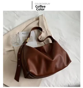 Detail of coffee brown hobo bag featuring lychee texture and metallic strap eyelets