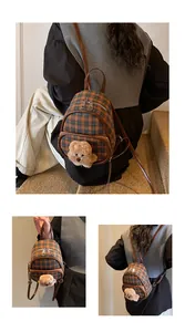 Détail du sac à dos en tweed à carreaux avec ours en peluche et bretelles en cuir