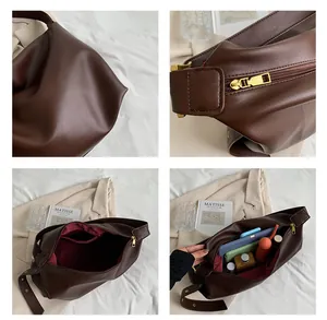 Detail view of large brown hobo bag showing interior capacity and golden hardware
