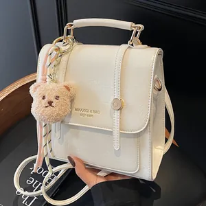Cream white glossy crocodile pattern backpack with plush bear charm and golden logo