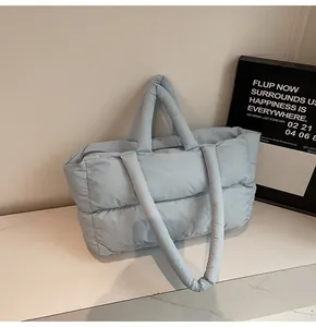Close-up of lightweight light blue quilted puffer tote bag with soft padded handles
