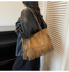 Macro detail of brown fringe tote bag featuring soft suede texture and layered tassels