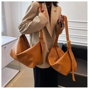 Detail of tan brown leather hobo bag with large gold buckle and adjustable wide strap
