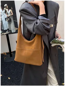 Detail of tan tote bag featuring contrasting white double stitching and front pocket design