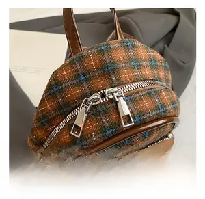 Détail du mini sac à dos en tweed avec fermetures éclair argentées et finitions en cuir