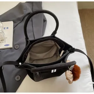 Draufsicht auf die schwarze matte Ledertasche mit grauem Innenfutter und Reißverschluss