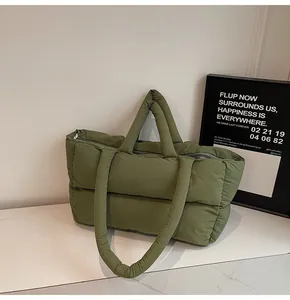 Detail view of olive green quilted puffer tote bag with dual handles and smooth zipper