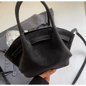Detailaufnahme der schwarzen matten Tasche mit Faltstruktur und Wildleder-Optik Textur