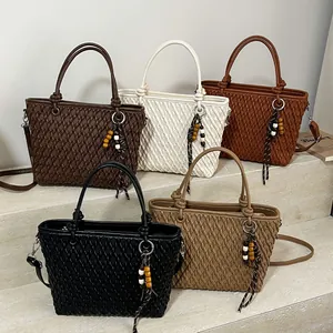 Textured woven tote bags in five colors on stone steps for minimalist autumn style