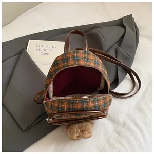 Détail du mini sac à dos en tweed à carreaux, bretelles en similicuir et breloque ourson
