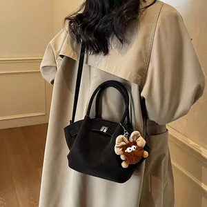 Schwarze Retro-Wildleder-Umhängetasche mit Silberschnalle und Plüschmonster-Anhänger