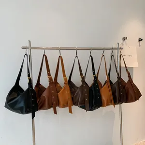 Minimalist leather crescent bags with wide grommet straps in neutral fall colors