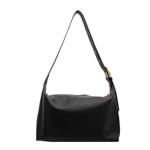 Minimalist black leather hobo tote bag with adjustable shoulder strap and gold hardware