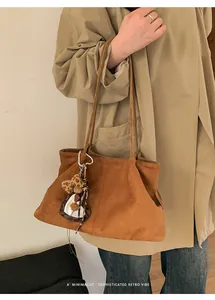 Détail du grand sac cabas en daim marron avec pendentif léopard et style vintage
