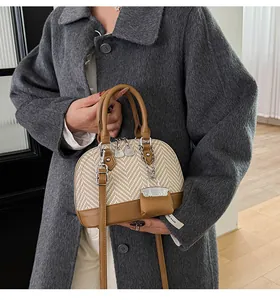 Detail of vintage shell bag showing khaki leather texture and woven fabric patchwork