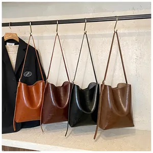 Detail view of large retro oil-wax leather bucket bags in brown, black and green colors
