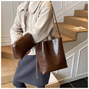 Detailed view of deep brown vintage leather bucket bag and matching inner pouch set
