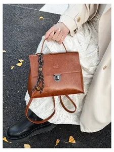 Nahaufnahme brauner Retro-Rucksack mit Metallschnalle und gewebtem Quasten-Detail