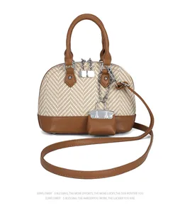 Detail of two-tone dome bag featuring herringbone weave texture and leather strap