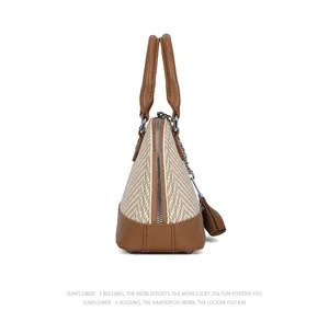 Detail of retro shell bag featuring beige woven fabric and brown leather patchwork