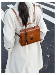 Nahaufnahme eines braunen Vintage-Lederrucksacks mit Metallschnalle an einem Model
