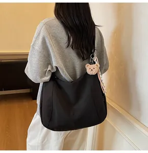 Vue arrière du mannequin portant un grand sac fourre-tout en nylon noir avec ours