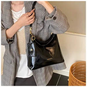 Detail der schwarzen Lackleder-Einkaufstasche mit kleiner Tasche und goldenen Beschlägen