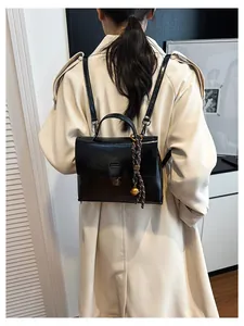 Detailansicht des schwarzen Vintage-Rucksacks mit Metallschloss und Glockenanhänger